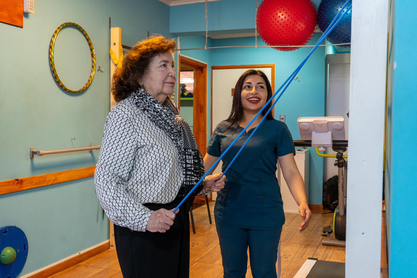 Kinesióloga guiando un ejercicio de rehabilitación funcional a una paciente